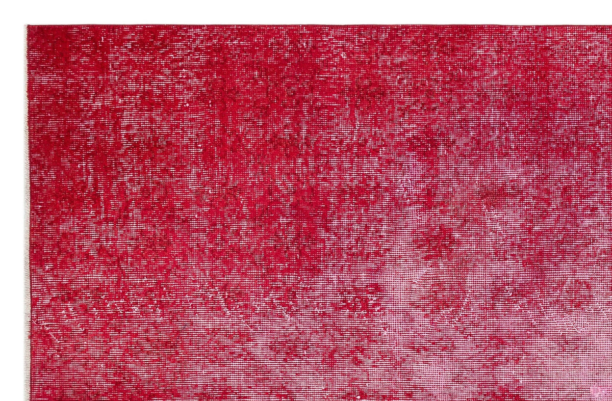 Deep red vintage-style rug with a distressed, faded texture and white fringe edge.