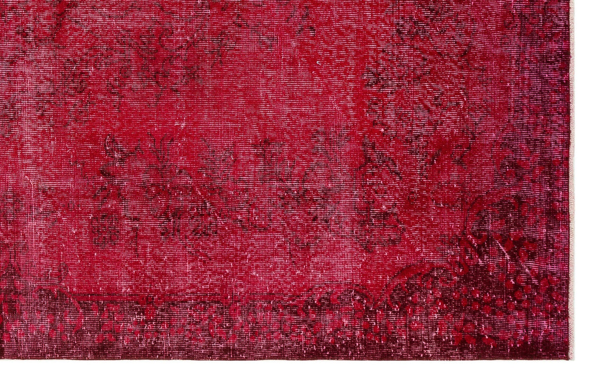 Deep red vintage-style rug with a distressed, faded floral medallion pattern and dark burgundy border.