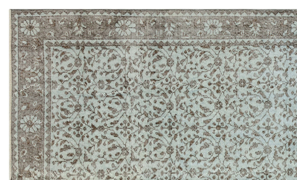 Light blue and brown rug with a traditional floral medallion pattern and a detailed border.