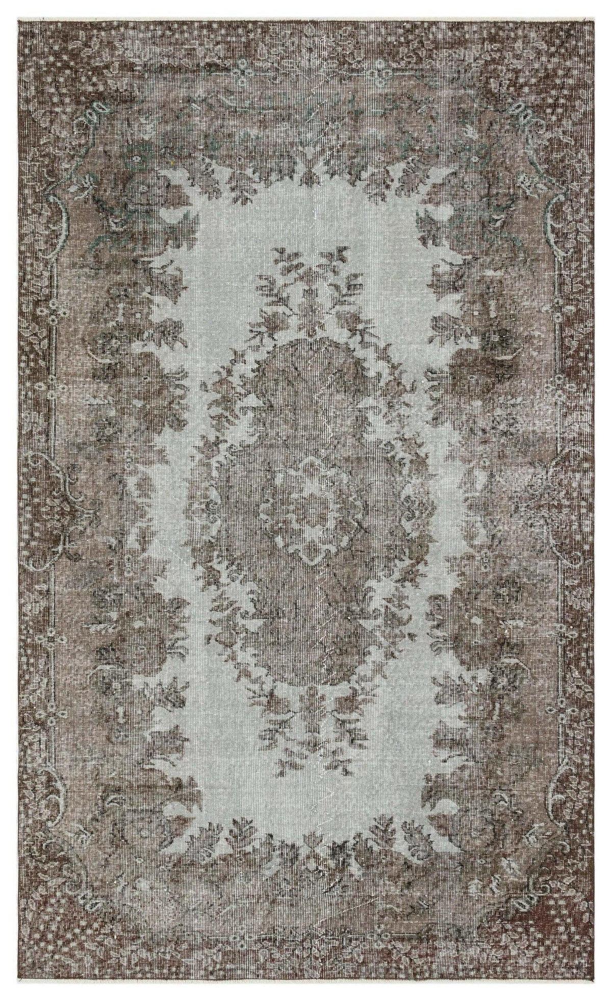 Distressed brown and light gray rug with a traditional central floral medallion and ornate border.