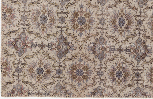 Load image 1 in gallery view. Beige rug with a repeating floral medallion pattern in muted tones of slate blue, brown, and dusty rose.