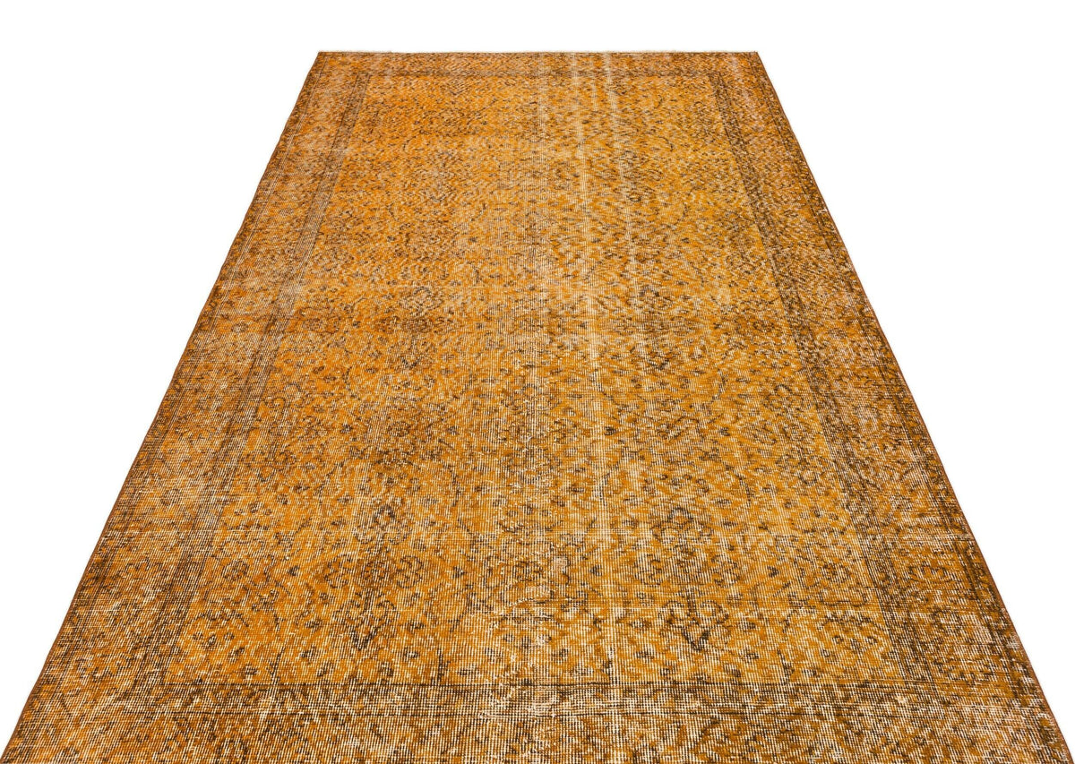 Ochre and brown vintage-style rug with a distressed traditional floral medallion pattern on a white background.