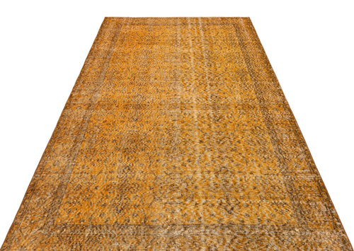 Load image 1 in gallery view. Ochre and brown vintage-style rug with a distressed traditional floral medallion pattern on a white background.