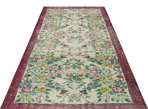 Load image 1 in gallery view. Beige runner rug with a distressed floral pattern in pink, yellow, and teal, featuring a wide burgundy border.