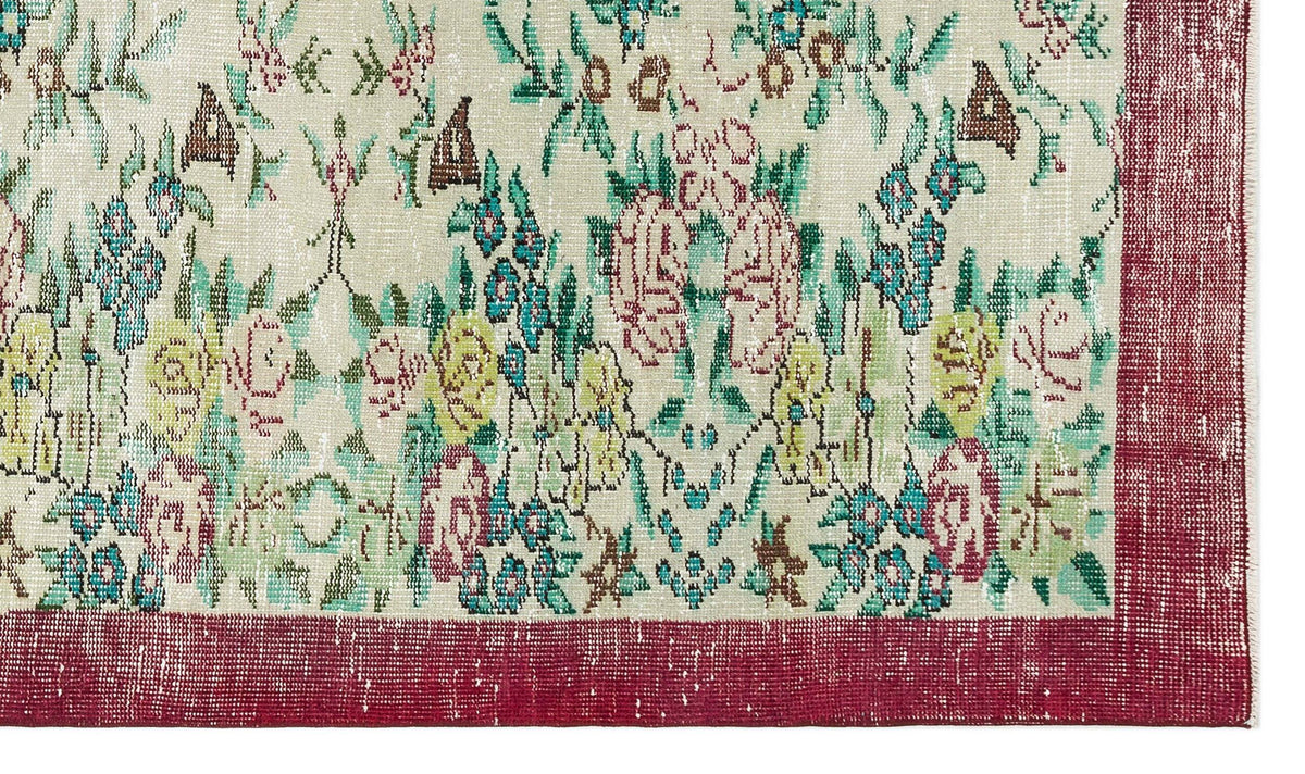 Distressed cream rug with a multi-colored floral pattern and a wide, solid red border.