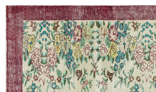 Load image 1 in gallery view. Distressed cream rug with a deep red border and a multicolored floral pattern in teal, yellow, and pink.