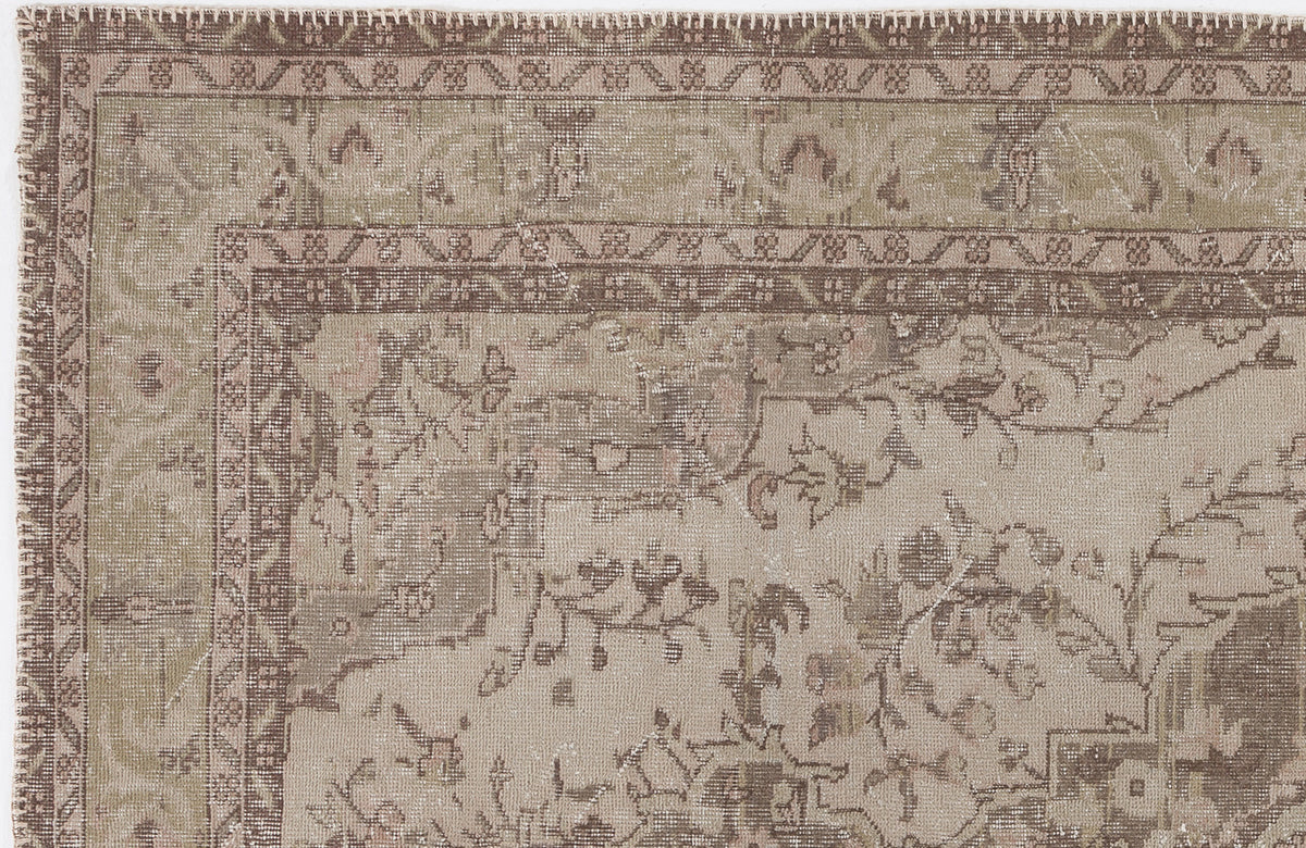 Taupe and brown vintage-style rug with a distressed floral medallion pattern and a geometric border.