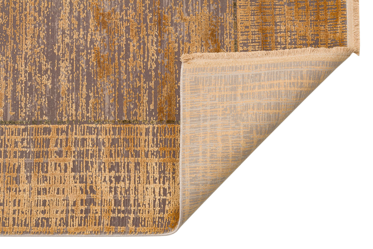 Gold and grey abstract rug with a distressed grid pattern, showing the woven backing and fringe on a white background.