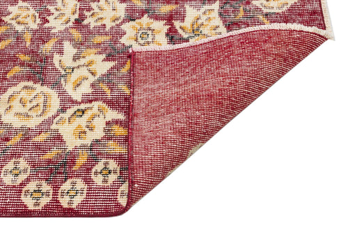 Load image 1 in gallery view. Deep red rug with cream and gold floral patterns, shown with a corner folded to reveal the woven backing.