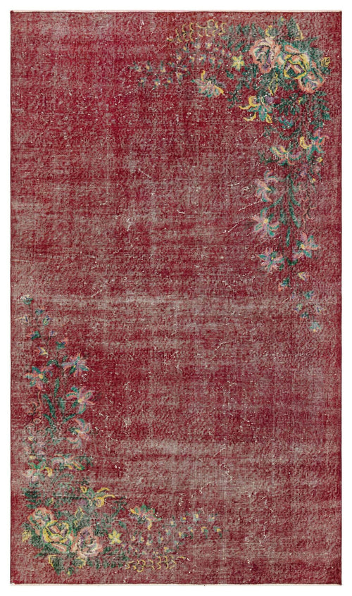 Load image 1 in gallery view. Distressed deep red rug with asymmetrical floral corner motifs in green, yellow, and pink on a white background.