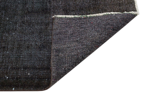 Load image 1 in gallery view. Charcoal grey rug with a textured, distressed finish and a folded corner revealing the dark woven backing.