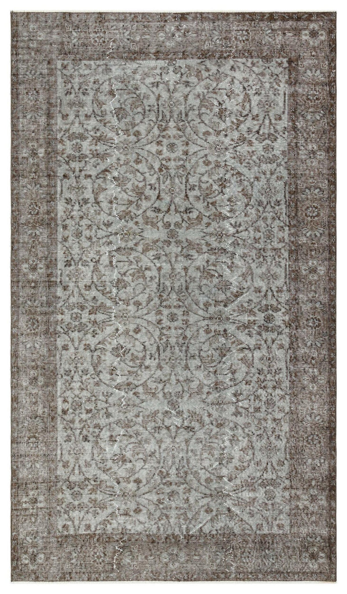 Distressed brown and grey rug with a traditional floral medallion pattern and a wide decorative border.