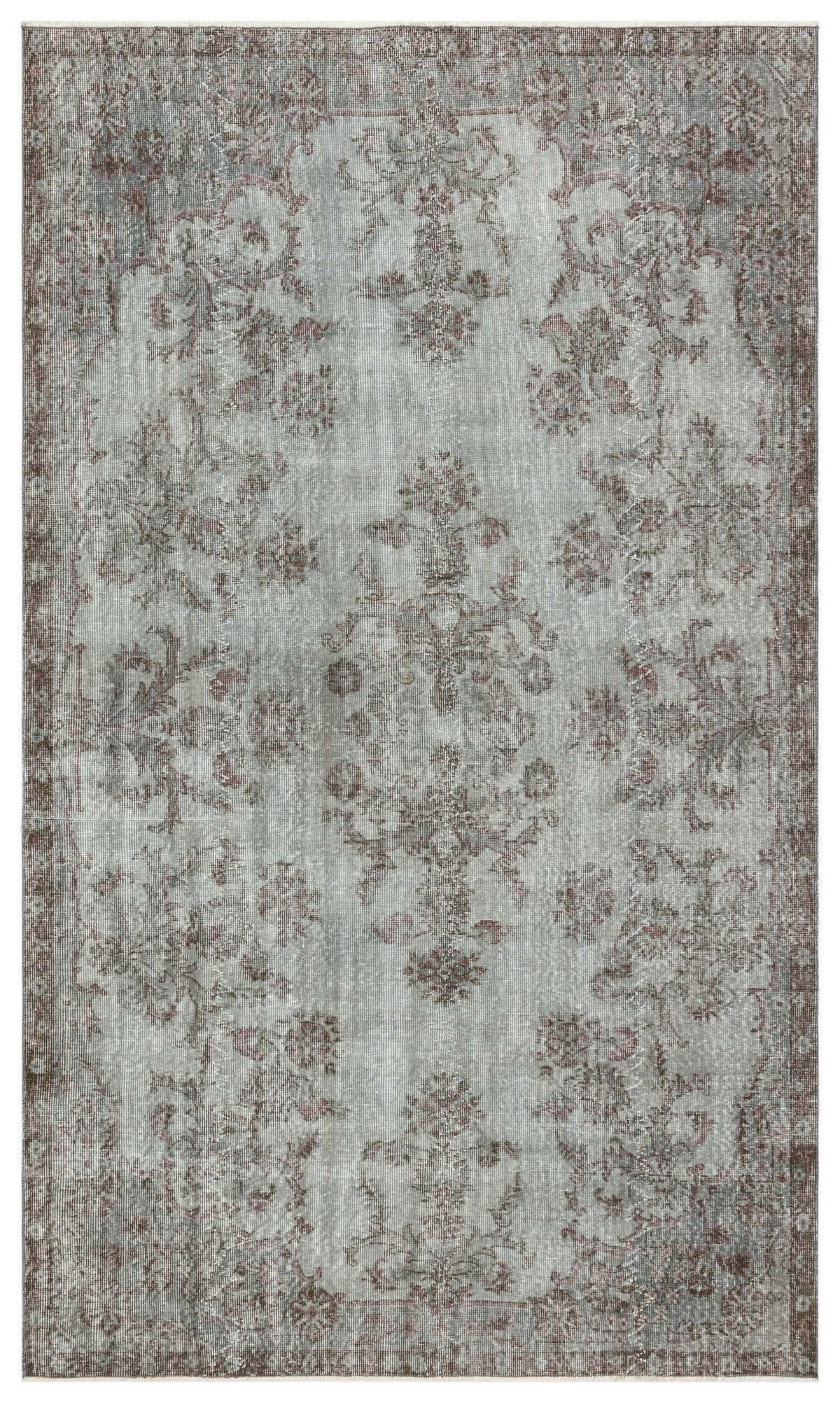 Distressed light gray and brown traditional rug with a central floral medallion and ornate border.
