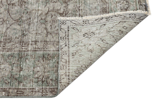 Load image 1 in gallery view. Distressed sage green and brown traditional medallion rug with a folded corner showing the woven backing.