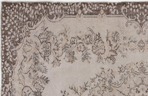 Load image 1 in gallery view. Beige and dark brown rug with a distressed floral medallion pattern and a decorative border.