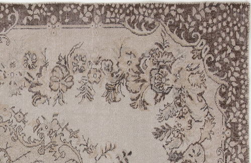 Load image 1 in gallery view. Beige and dark brown rug with a distressed floral medallion pattern and a decorative border.