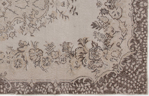 Load image 1 in gallery view. Beige and brown rug with a distressed floral medallion pattern and a wide decorative border.