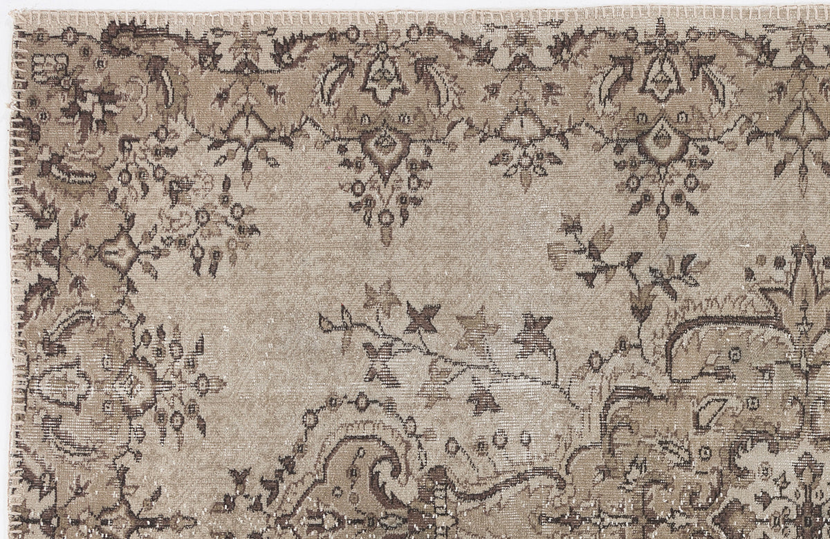 Beige and brown vintage-style rug with a distressed floral and paisley pattern.