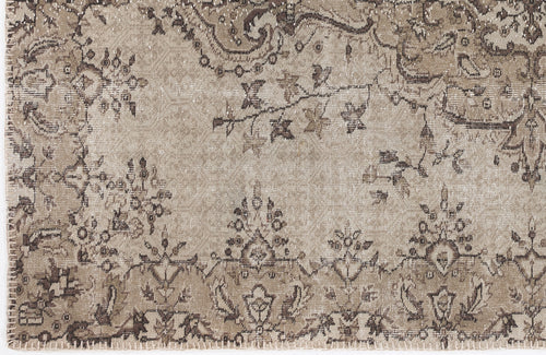 Load image 1 in gallery view. Beige and brown distressed rug with a traditional floral medallion and vine pattern.