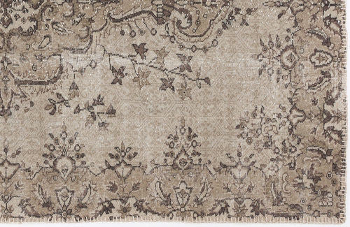 Load image 1 in gallery view. Taupe and dark brown distressed rug with a traditional floral medallion pattern and a stitched edge.