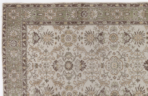 Load image 1 in gallery view. Beige, sage green, and brown traditional rug with a distressed floral medallion pattern and a decorative border.