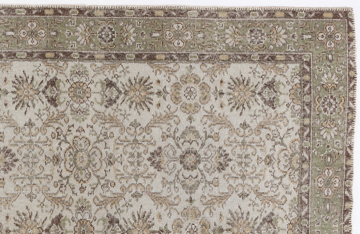 Sage green, brown, and cream traditional rug with a detailed floral medallion pattern and a decorative border.