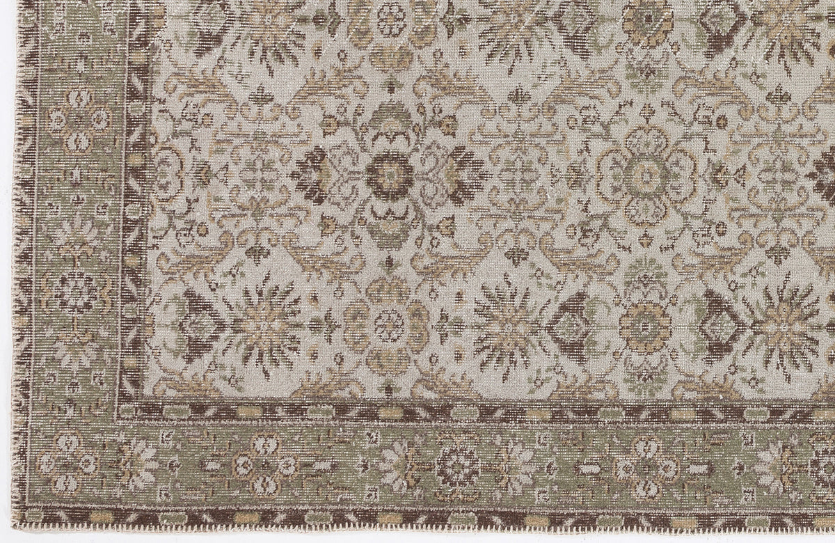 Beige, brown, and sage green traditional rug with a distressed floral medallion pattern and a decorative border.