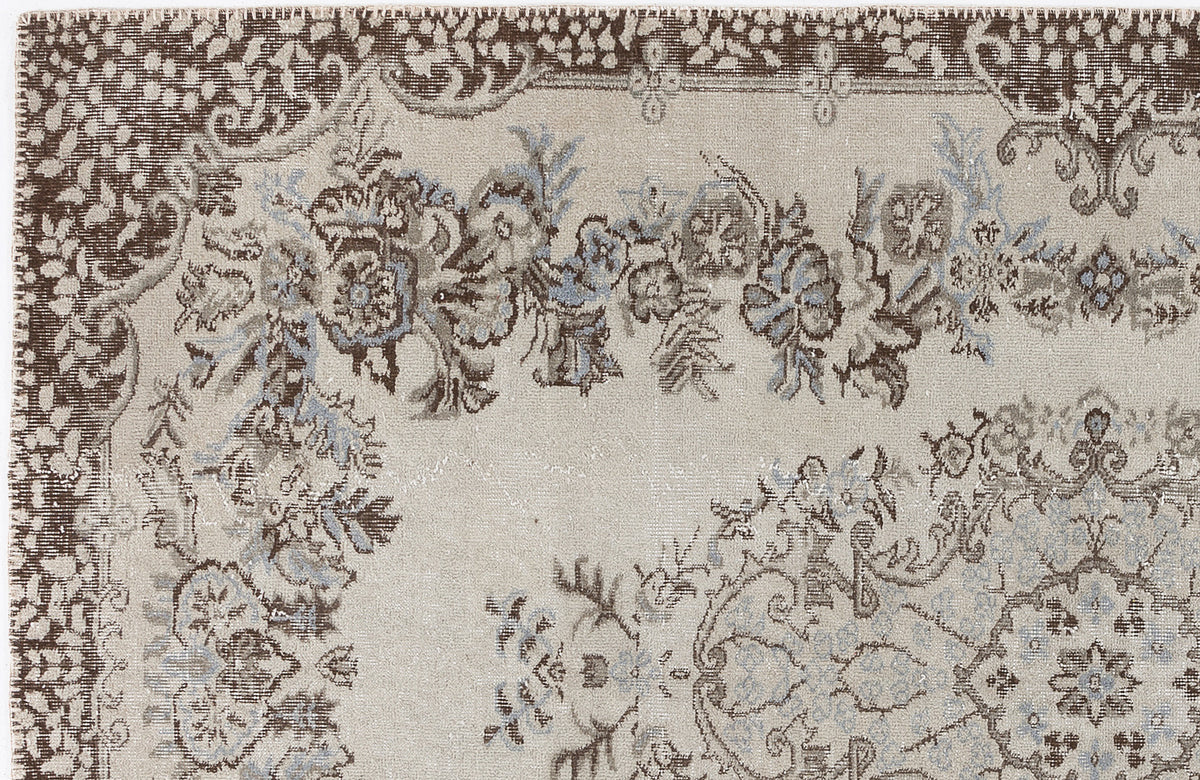 Beige, brown, and light blue traditional floral medallion rug with a distressed, vintage-inspired finish.
