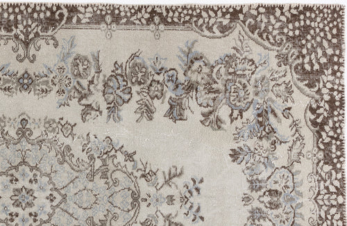 Load image 1 in gallery view. Beige rug with a distressed brown and light blue floral medallion pattern and a decorative border.