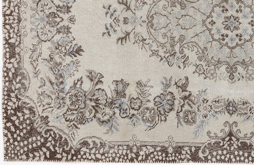 Load image 1 in gallery view. Beige rug with a distressed brown and light blue floral medallion pattern and ornate border.