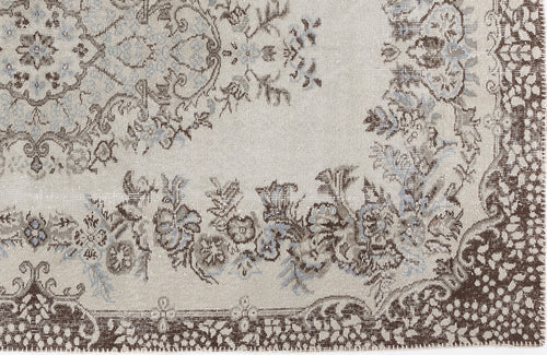 Load image 1 in gallery view. Beige rug with a distressed floral medallion pattern in brown and slate blue.