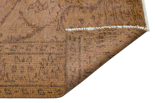 Load image 1 in gallery view. Tan and brown distressed traditional rug with a folded corner revealing a white fringe edge on a white background.