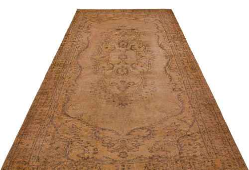 Load image 1 in gallery view. Distressed brown vintage rug with a central floral medallion and ornate border on a white background.