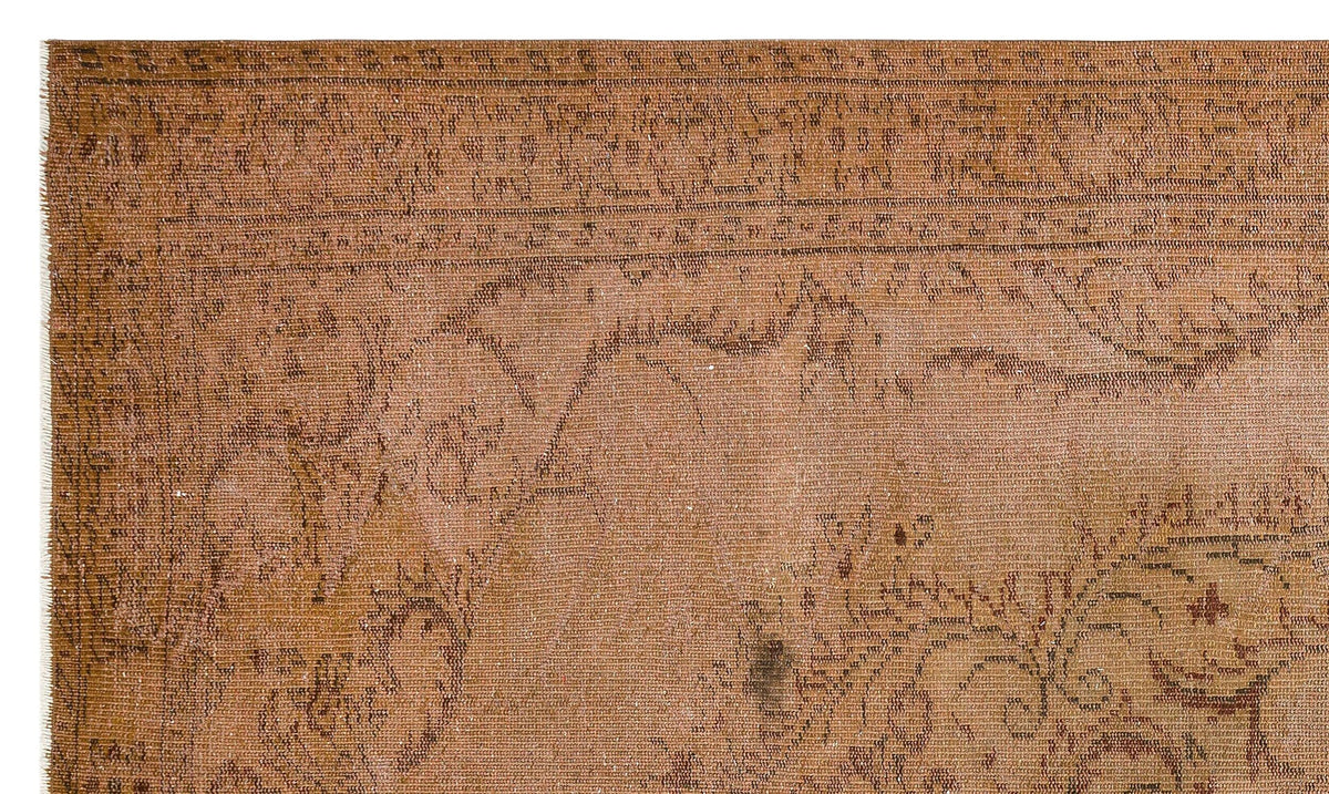 Distressed terracotta rug with a faded traditional floral border and central medallion pattern.