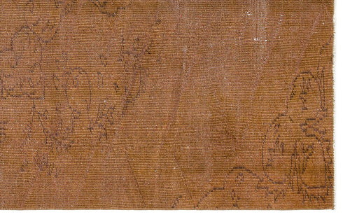 Load image 1 in gallery view. Distressed tobacco-brown rug with a faint, dark linear floral pattern and visible woven texture.