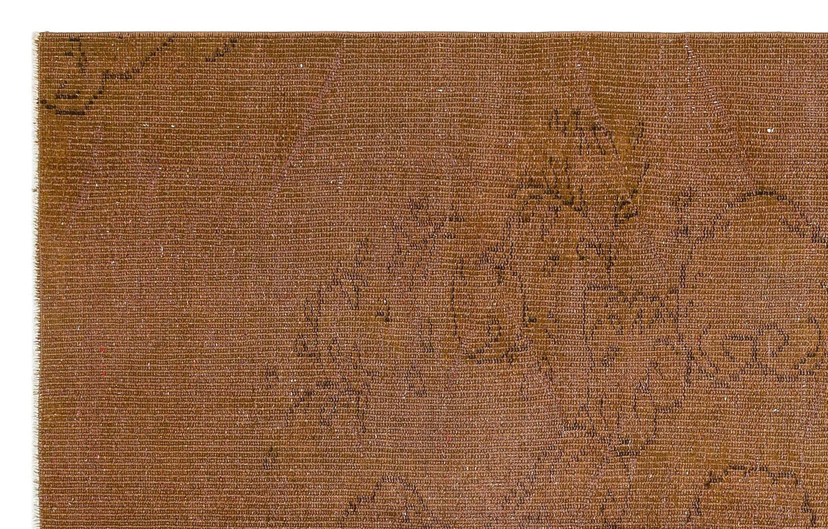 Distressed rust-brown rug with a faint, dark linear floral pattern and visible woven texture.