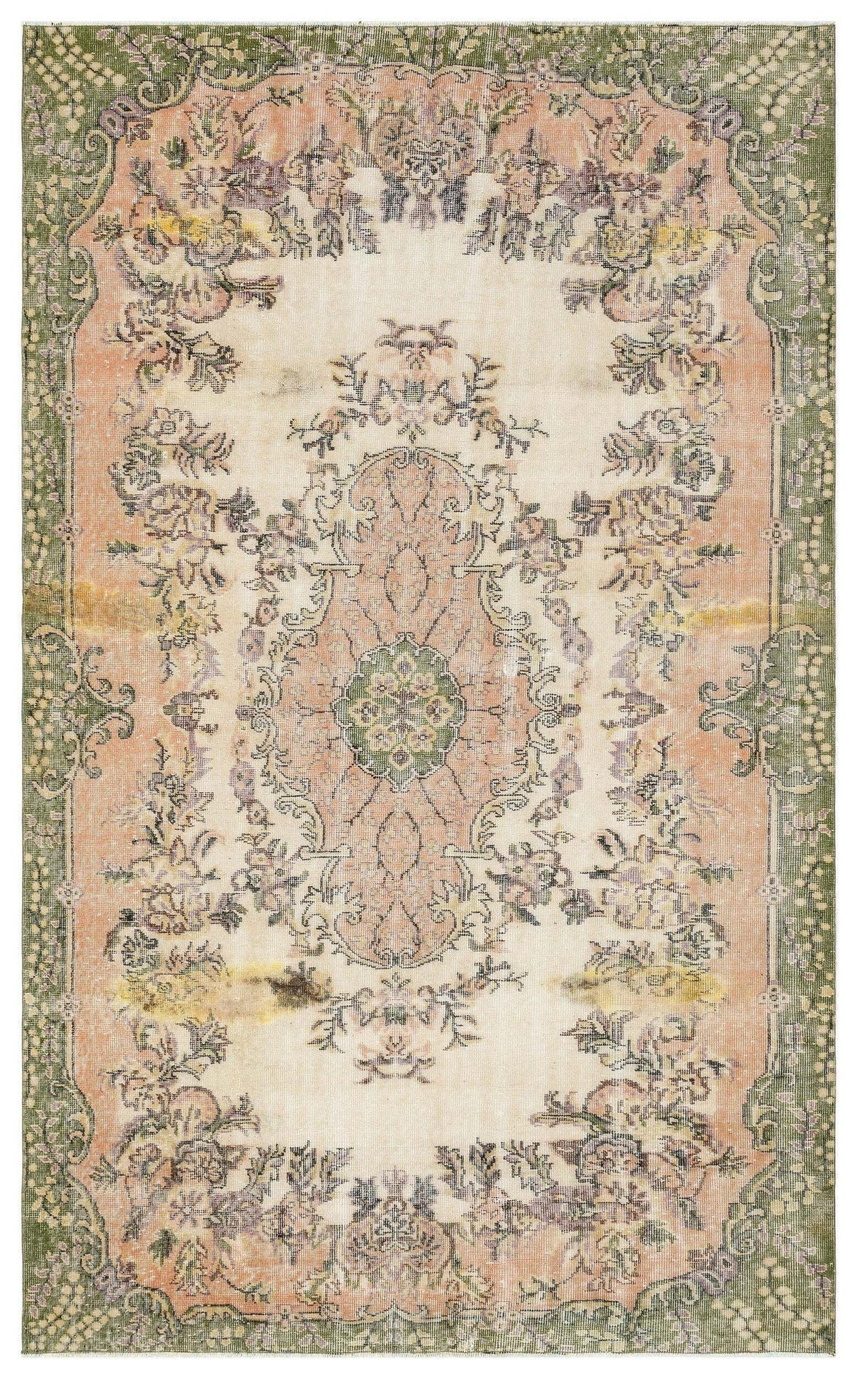Distressed vintage-style rug with a central floral medallion, featuring muted green, peach, and cream tones.