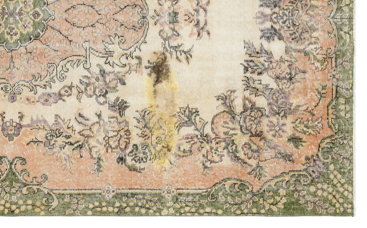 Distressed cream rug with a faded floral medallion pattern in muted peach, green, and charcoal on a white background.