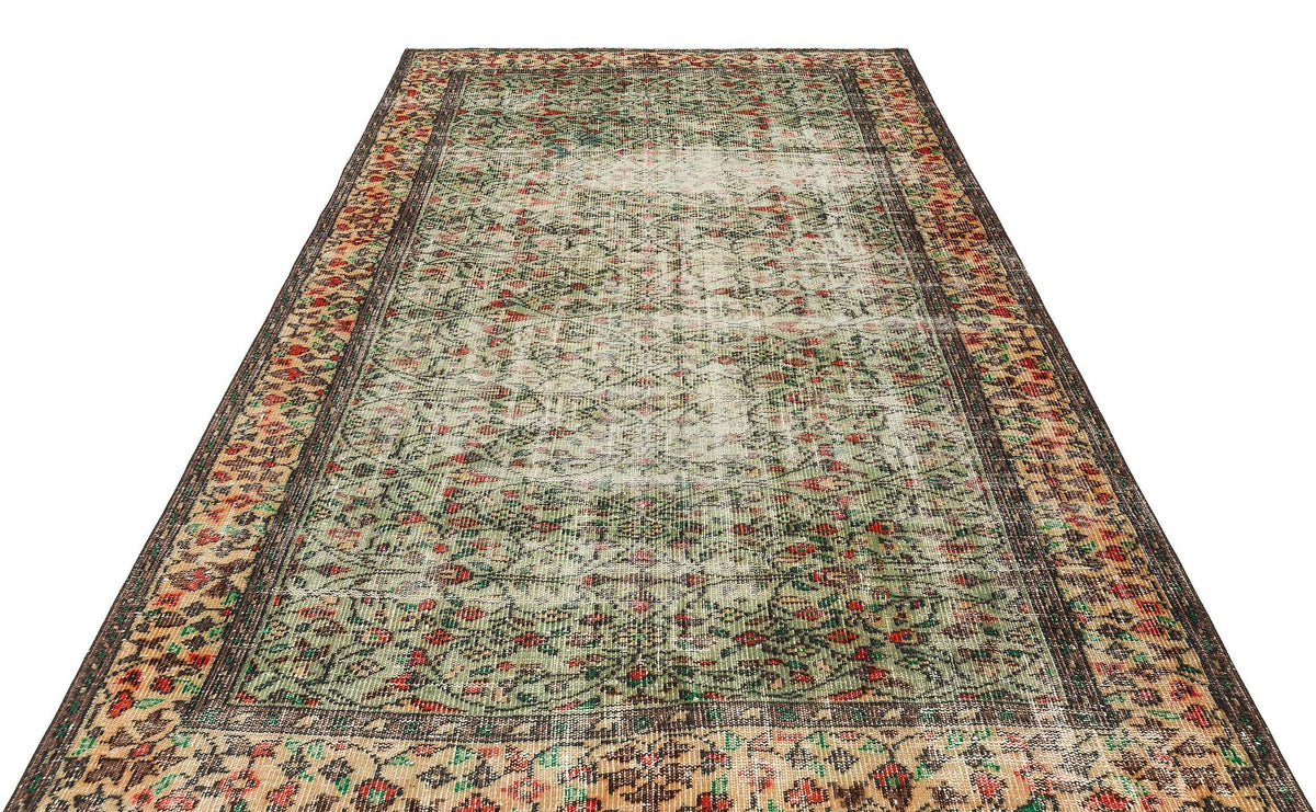 Distressed vintage-style rug with a green, red, and beige floral pattern and a dark brown border on a white background.