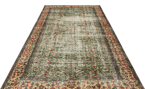 Load image 1 in gallery view. Distressed vintage-style rug with a green, red, and beige floral pattern and a dark brown border on a white background.