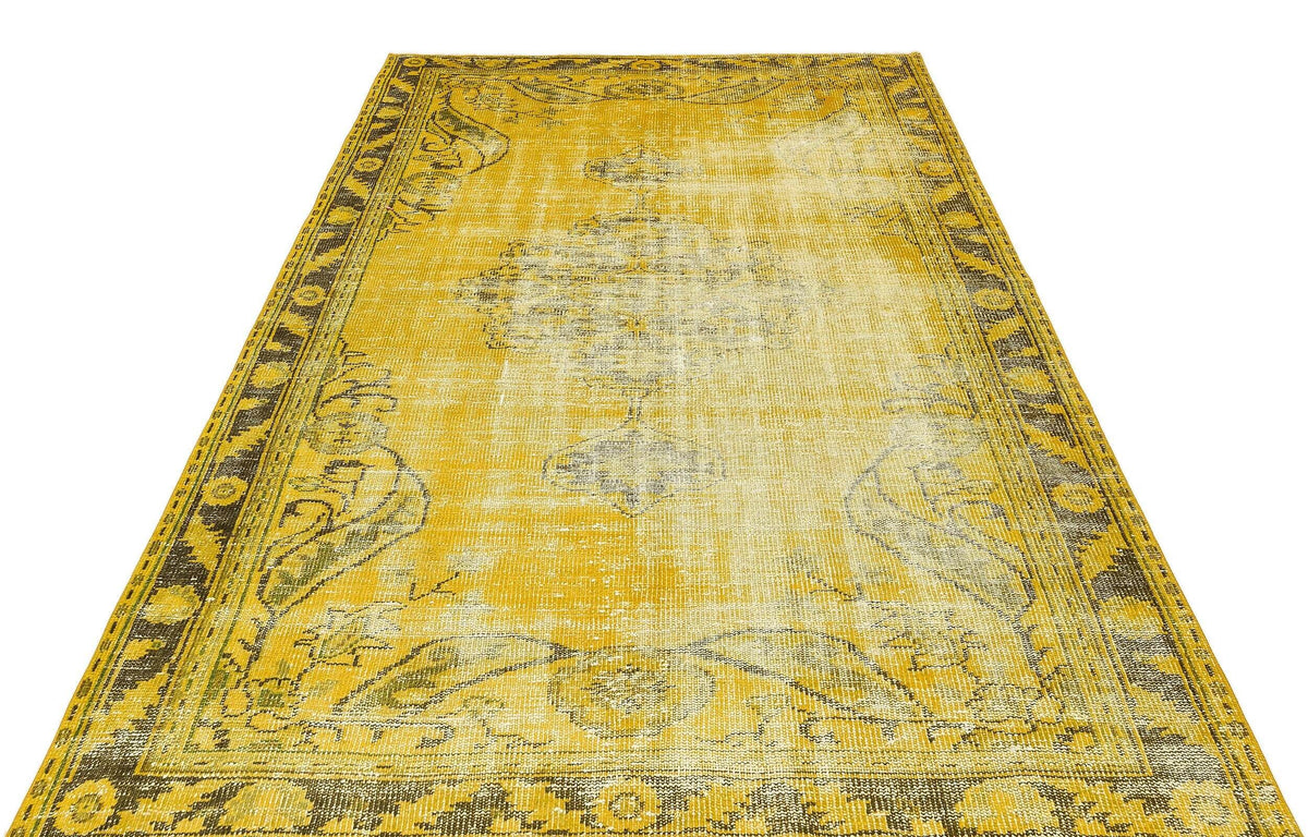 Mustard yellow and charcoal distressed rug with a traditional central medallion and ornate border pattern.