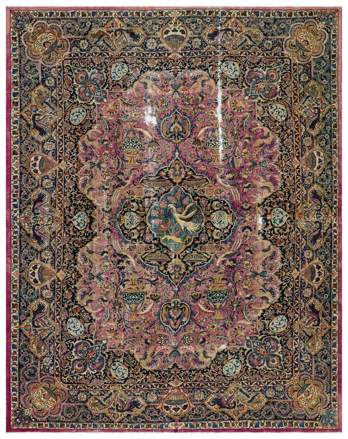 Traditional Persian-style rug with a central bird medallion, intricate floral motifs, and a dark blue and pink palette.
