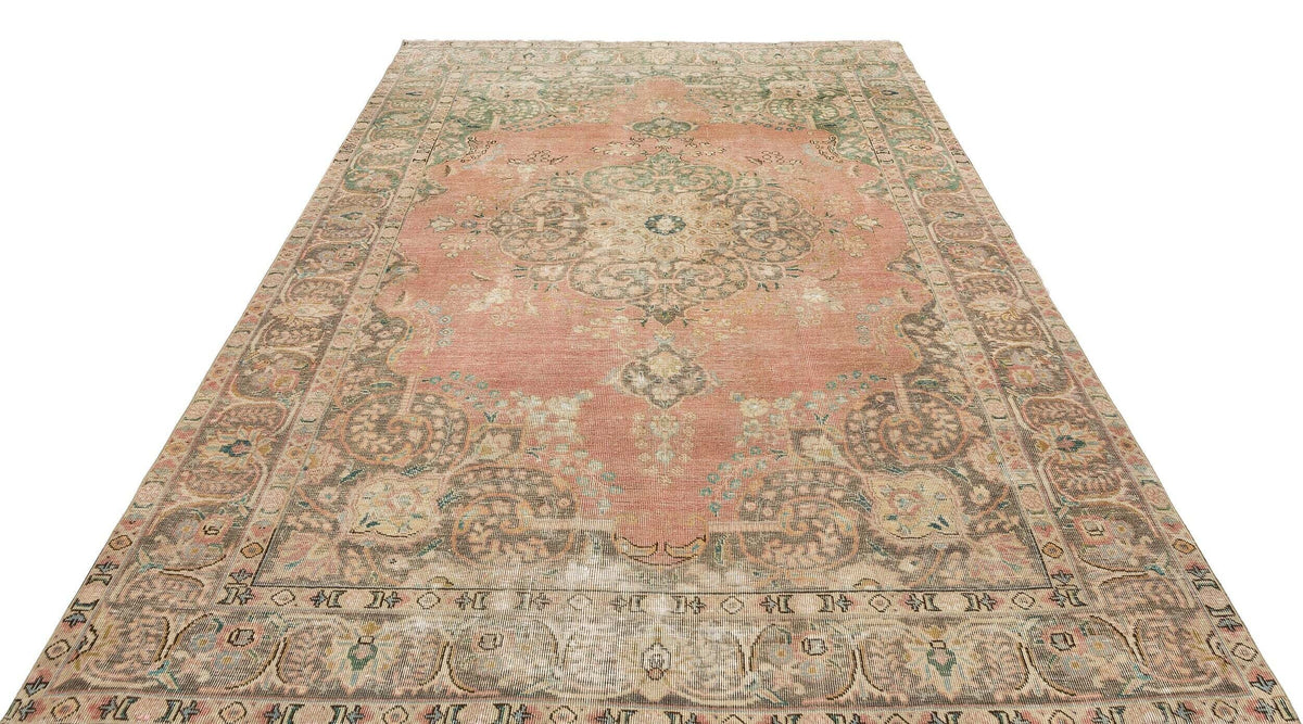 Distressed coral and sage green traditional rug with a central floral medallion and ornate border on a white background.