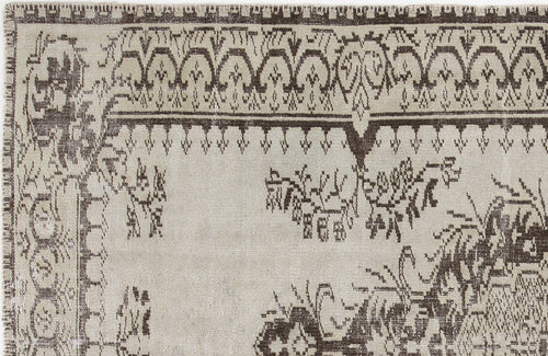 Load image 1 in gallery view. Beige and dark brown rug with a distressed traditional border and central floral motif.