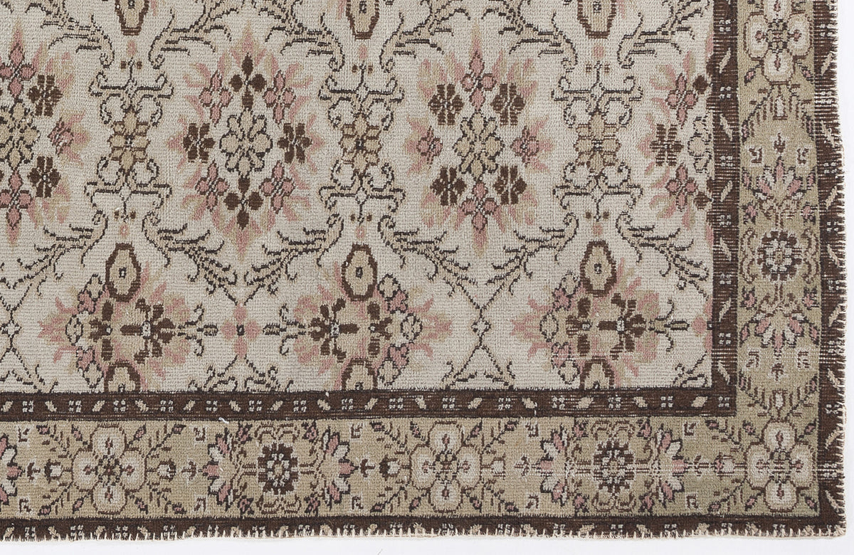 Cream, brown, and dusty pink rug with a traditional floral medallion pattern and a wide decorative border.