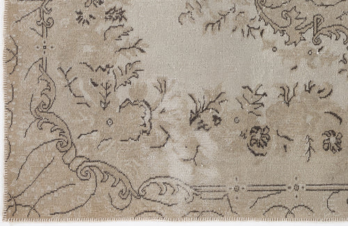 Load image 1 in gallery view. Beige and taupe distressed rug with a faded traditional floral medallion pattern and a stitched edge.