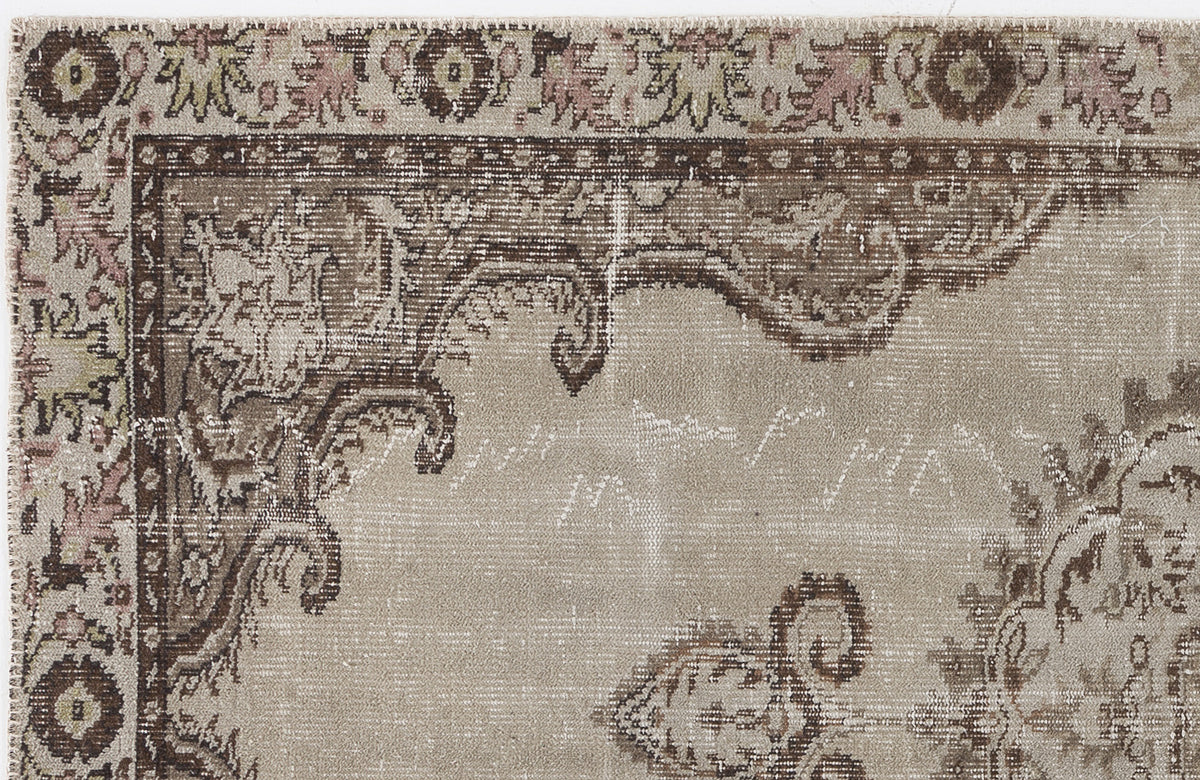 Beige and brown distressed rug with a traditional floral medallion border and faded ornate patterns.
