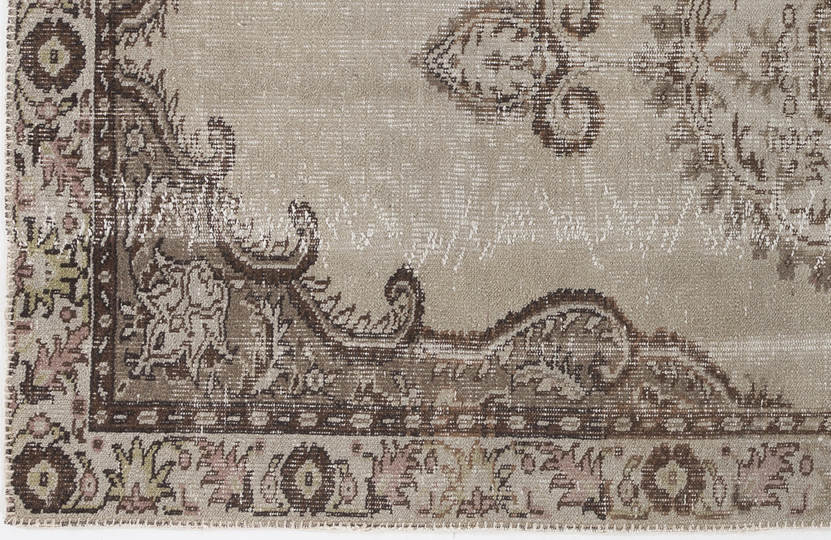 Taupe and brown distressed rug with a traditional ornate medallion pattern and faded vintage texture.