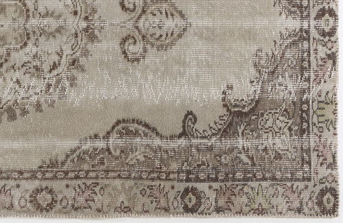 Load image 1 in gallery view. Taupe and brown distressed rug with a faded traditional floral medallion pattern.