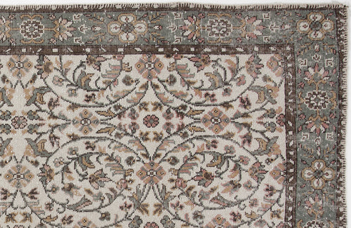 Load image 1 in gallery view. Distressed traditional rug with a cream field, sage green border, and intricate floral vine pattern in muted earth tones.